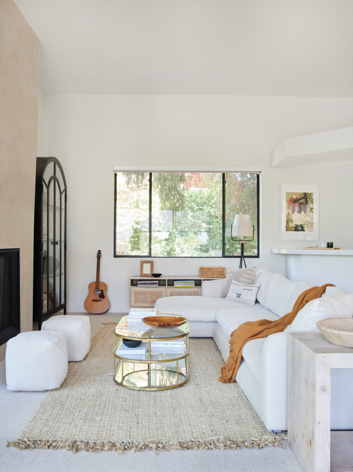 neutral living room with cozy white sectional, jute rug, and glass coffee table