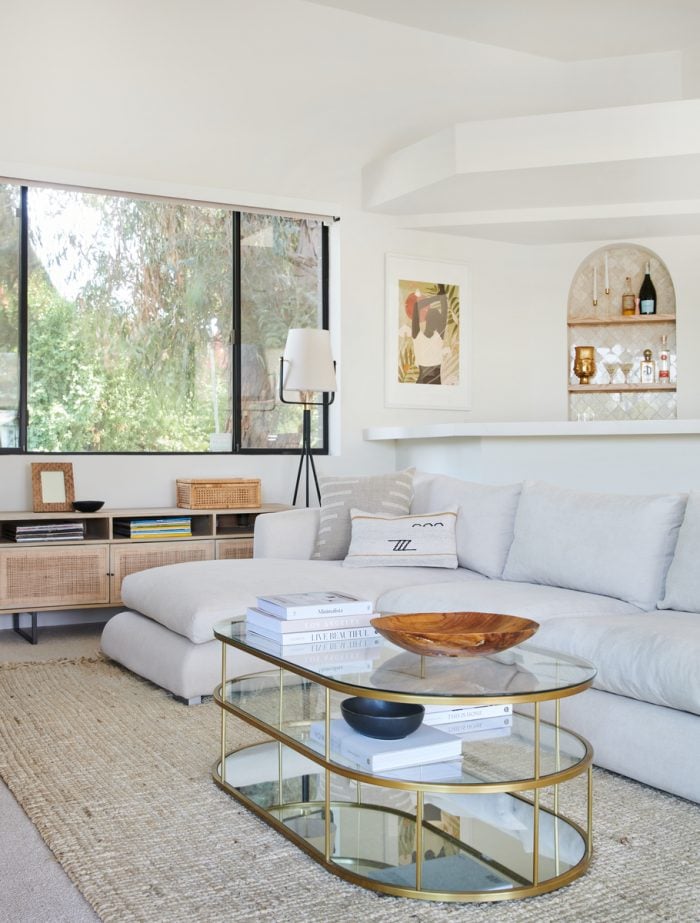 modern glass coffee table and white sectional on jute rug