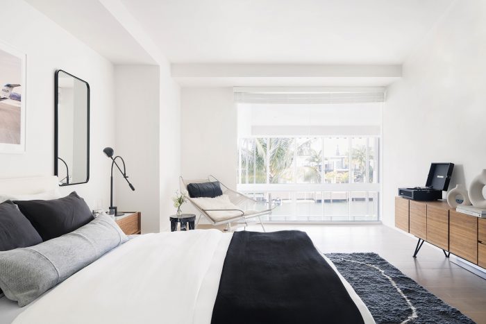 modern bedroom with white bedding and black rug