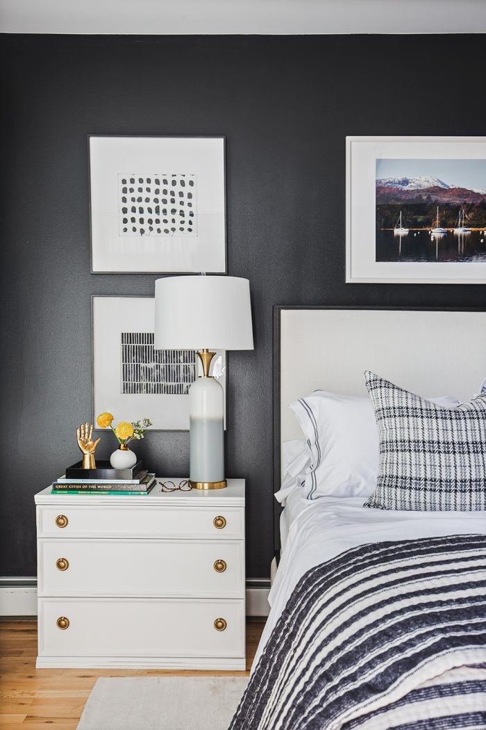 black bedroom with white glam nightstand and black and white bedding