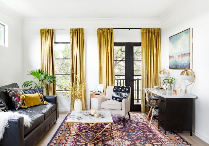 bright living room with leather sofa, modern desk, and gold velvet curtains